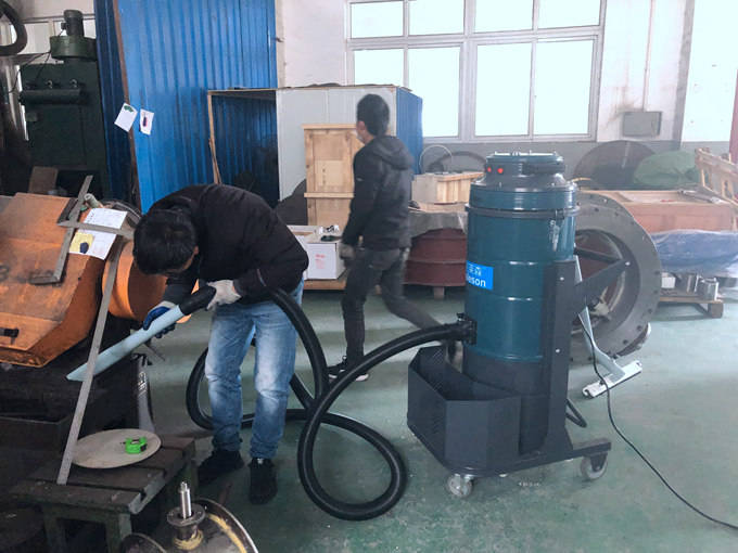 车间中工人正在使用克莱森吸尘器清理设备上碎屑
